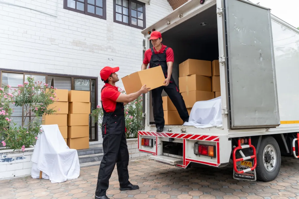Dos operarios descargando cajas de un camión